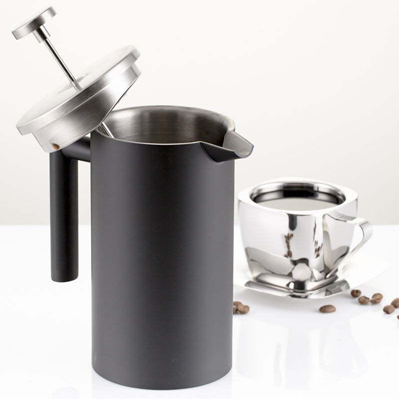 Black stainless steel french press with filter in use